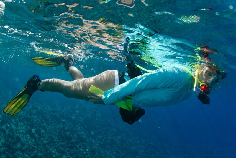 Snorkeler at the water surface wearing a Spare Air Xtreme 6 Mini-SCUBA system.