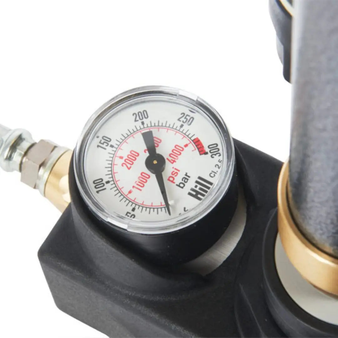 High-pressure hand pump gauge displaying PSI and BAR readings during manual air filling.