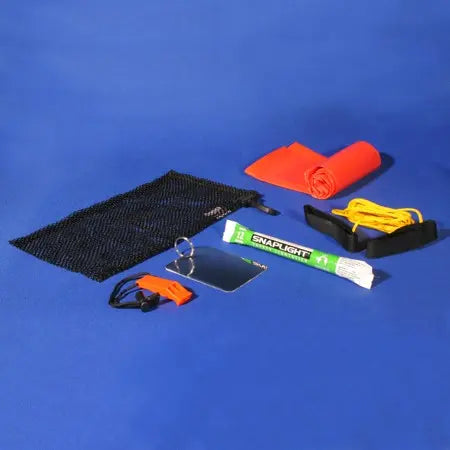 Contents of an S.O.S. diver safety signaling kit including surface marker buoy, whistle, signal mirror, snap light, and mesh bag.
